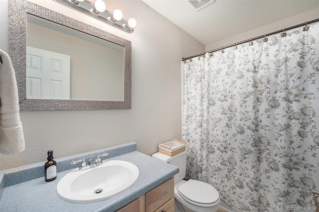 5252 W 68th Ave, Arvada, CO 80003 - bathroom featuring toilet, vanity, a textured wall, and a shower with shower curtain