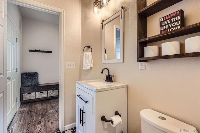 7485 S Jackson Gap Way, Aurora, CO 80016 - bathroom featuring vanity, toilet, wood finished floors, and baseboards