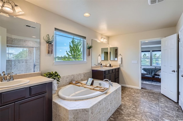 7485 S Jackson Gap Way, Aurora, CO 80016 - ensuite bathroom featuring two vanities, a bath, a stall shower, and recessed lighting