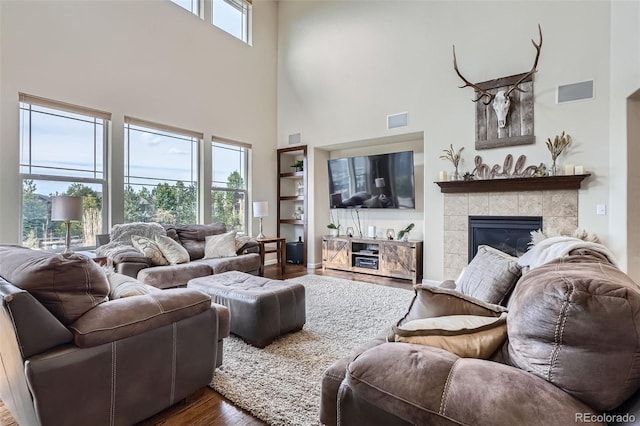 7485 S Jackson Gap Way, Aurora, CO 80016 - living room with a high ceiling, wood finished floors, and a tile fireplace