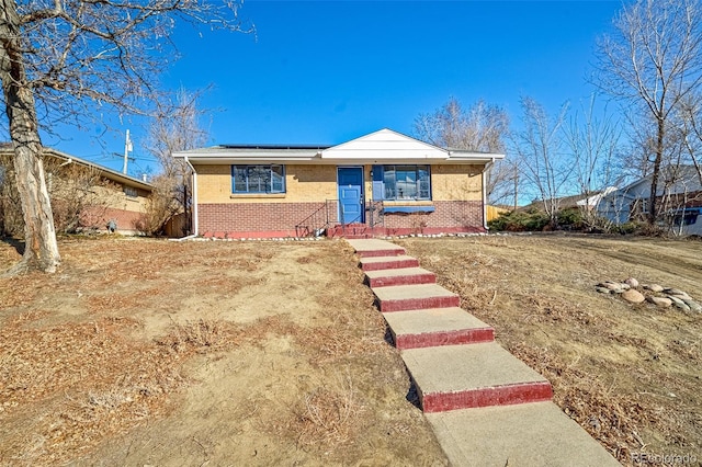 view of front of property with solar panels and brick siding