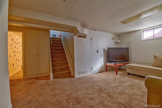 below grade area with visible vents, stairway, and carpet flooring