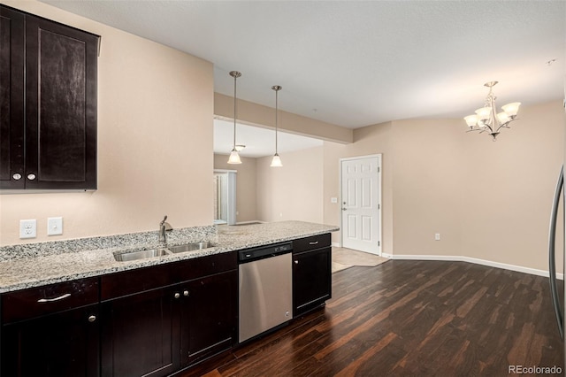 kitchen featuring dark hardwood / wood-style floors, stainless steel dishwasher, sink, hanging light fixtures, and light stone countertops