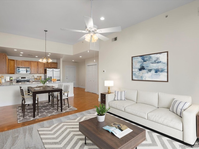 living room with baseboards, visible vents, light wood-style flooring, recessed lighting, and ceiling fan