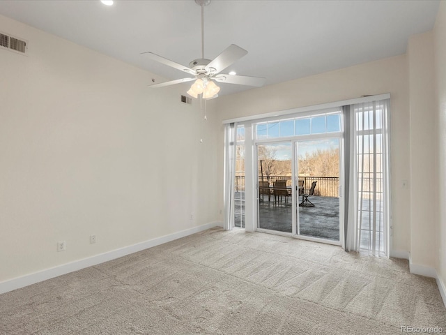 spare room with ceiling fan, carpet, visible vents, and baseboards