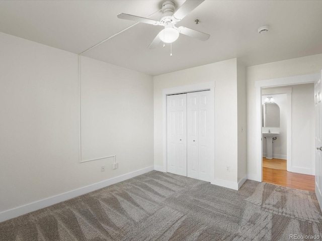 unfurnished bedroom featuring a closet, baseboards, carpet, and a ceiling fan