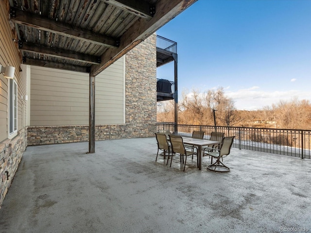 view of patio with outdoor dining area and a balcony