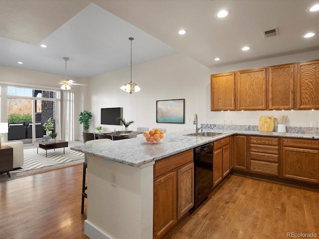 kitchen featuring pendant lighting, dishwasher, sink, kitchen peninsula, and light wood-type flooring