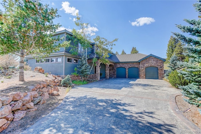 28154 Belle Mont Trl, Conifer, CO 80433 - view of front of property with a garage, driveway, and stone siding