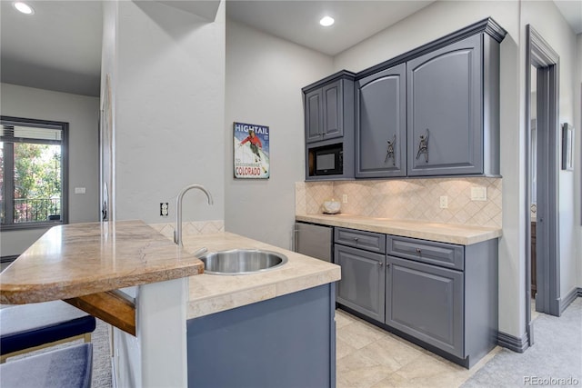 28154 Belle Mont Trl, Conifer, CO 80433 - kitchen featuring a sink, a peninsula, black microwave, a kitchen breakfast bar, and decorative backsplash