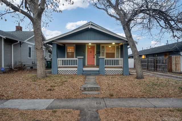 bungalow-style house with a porch and fence