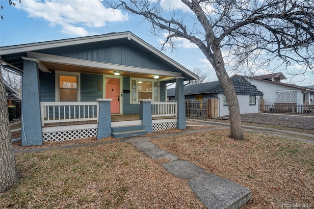 bungalow-style house with a porch and fence