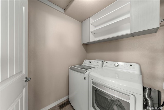 clothes washing area featuring laundry area, baseboards, and independent washer and dryer