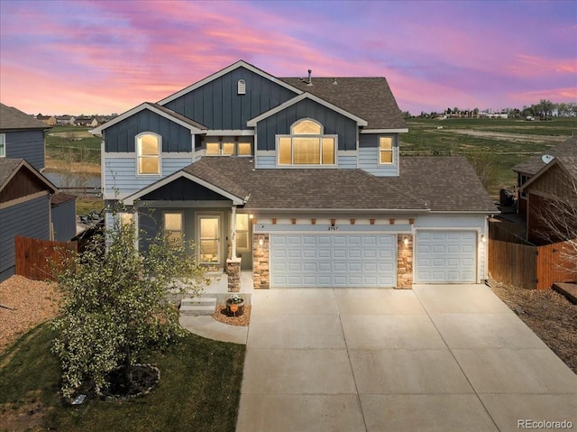 traditional-style house featuring roof with shingles, board and batten siding, fence, and concrete driveway
