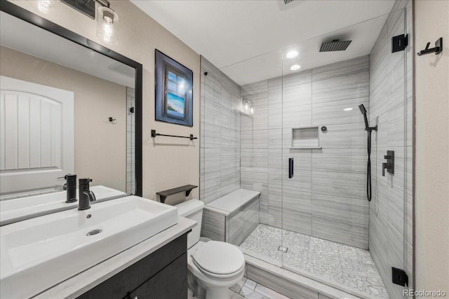 full bathroom featuring vanity, a stall shower, and toilet