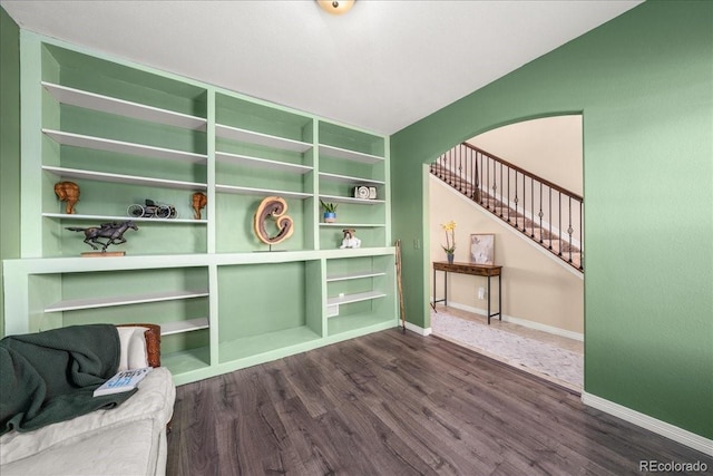 unfurnished room featuring stairway, baseboards, and dark wood-style floors