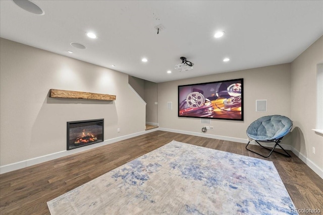 home theater with recessed lighting, baseboards, a glass covered fireplace, and wood finished floors
