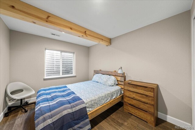bedroom featuring baseboards, visible vents, and wood finished floors