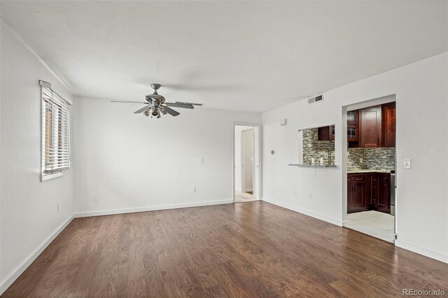 spare room with light wood finished floors, ceiling fan, and baseboards