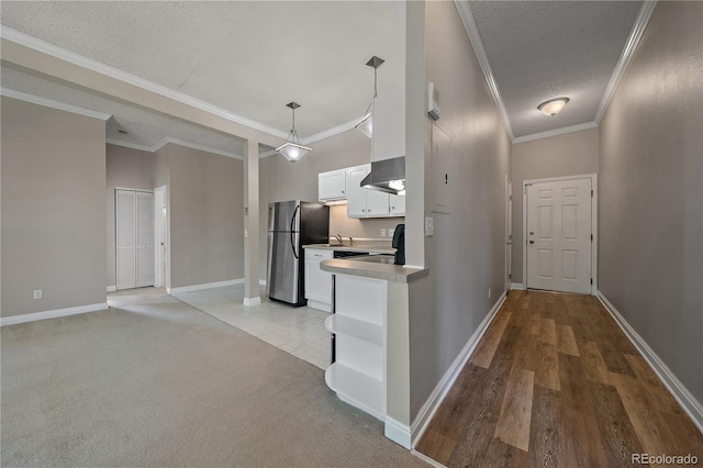 kitchen featuring pendant lighting, a textured ceiling, white cabinetry, and stainless steel refrigerator