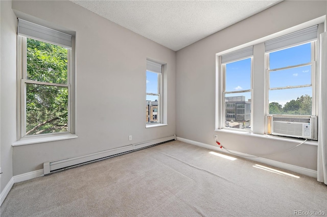 carpeted empty room with cooling unit, a healthy amount of sunlight, a textured ceiling, and a baseboard radiator