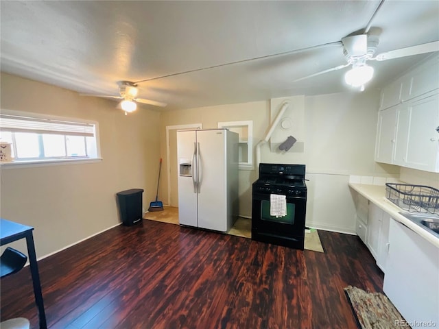 kitchen featuring white cabinetry, white refrigerator with ice dispenser, black gas range oven, and dark wood-type flooring