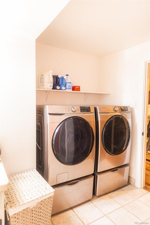 laundry area featuring light tile patterned floors and separate washer and dryer