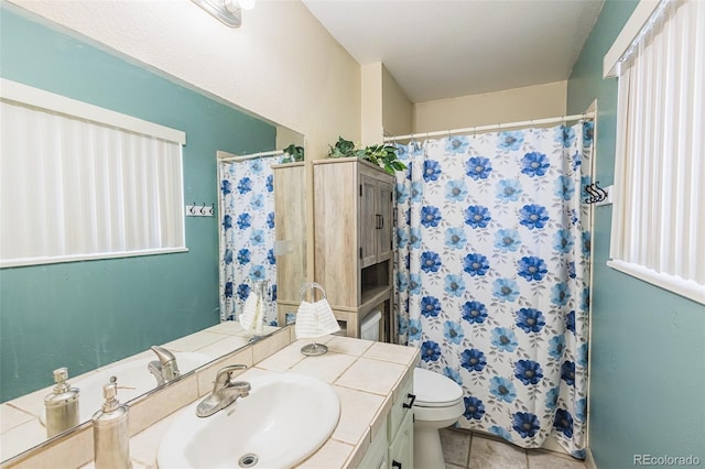 bathroom with a shower with shower curtain, tile patterned floors, vanity, and toilet