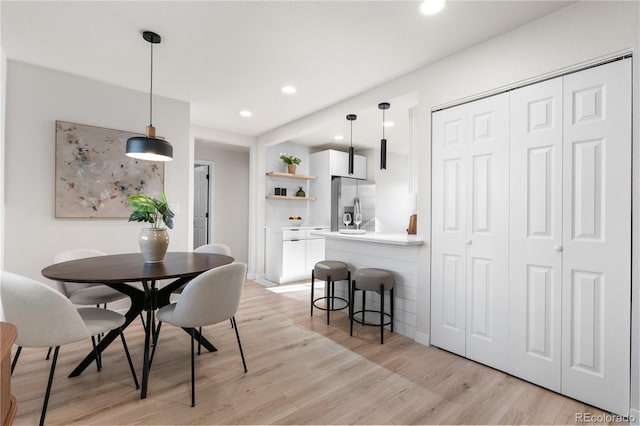 dining space featuring light wood finished floors and recessed lighting