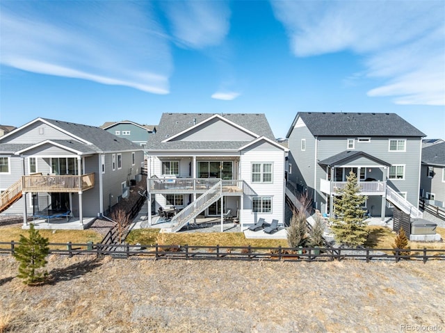 back of property with stairway, a residential view, a wooden deck, and a fenced backyard