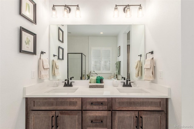 bathroom featuring a sink, a shower with door, and double vanity