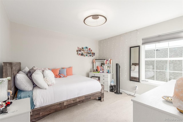 bedroom featuring baseboards and light carpet