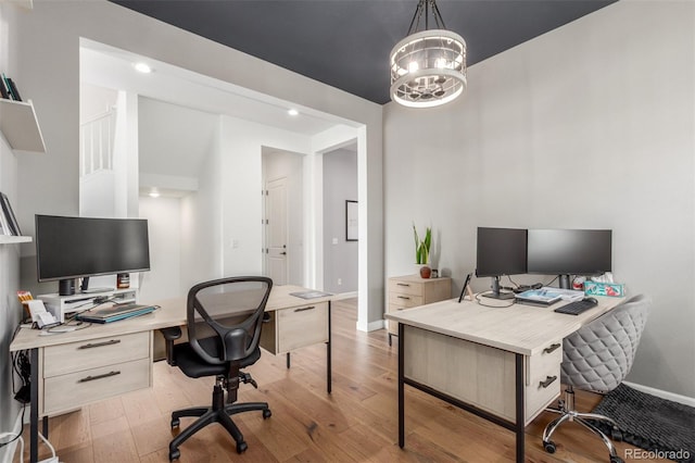 home office with a chandelier, baseboards, and hardwood / wood-style floors