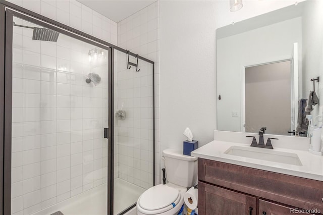 bathroom featuring vanity, toilet, and a shower stall