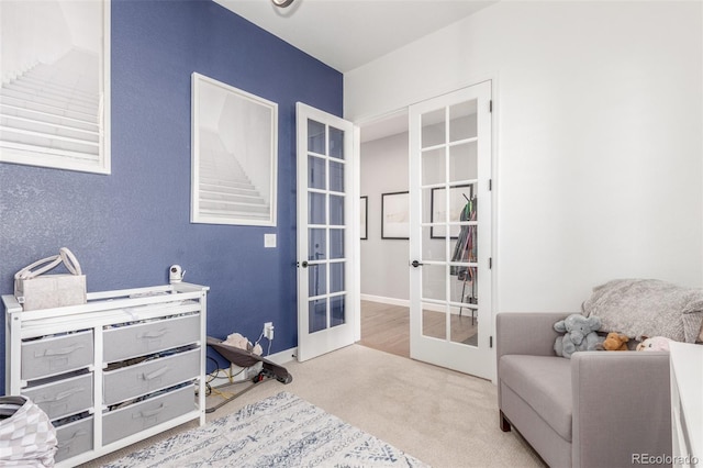 sitting room with french doors, baseboards, and carpet floors