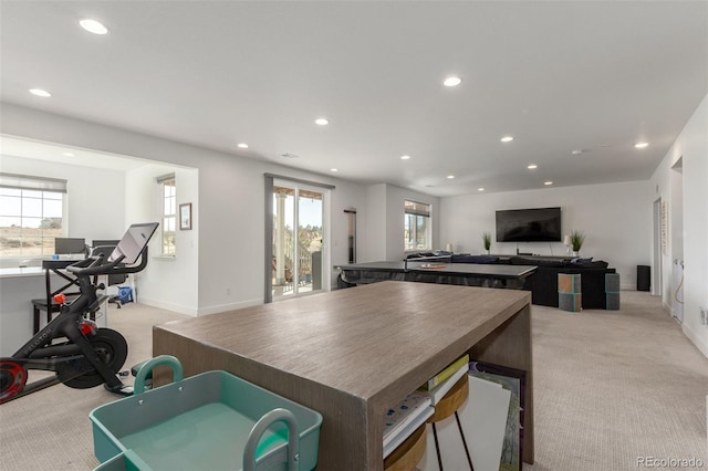 interior space featuring recessed lighting, a wealth of natural light, light carpet, and open floor plan