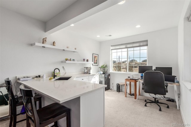 interior space featuring open shelves, light carpet, recessed lighting, and a sink