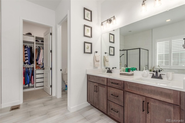 22773 E Narrowleaf Cir, Aurora, CO 80016 - full bath featuring a shower stall, baseboards, double vanity, a walk in closet, and toilet