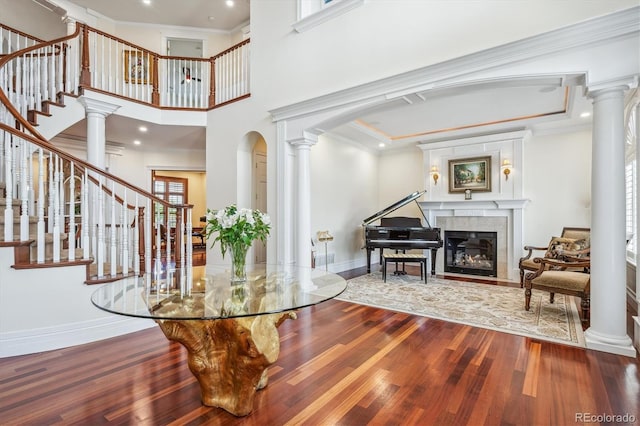 8717 Ridgepoint Dr, Castle Pines, CO 80108 - entryway featuring ornate columns, wood finished floors, a glass covered fireplace, arched walkways, and recessed lighting