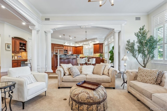 8717 Ridgepoint Dr, Castle Pines, CO 80108 - living area with decorative columns, arched walkways, light colored carpet, crown molding, and a chandelier