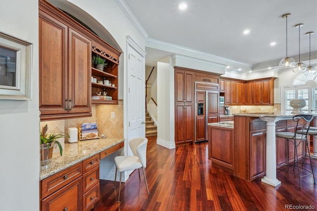8717 Ridgepoint Dr, Castle Pines, CO 80108 - kitchen featuring built in study area, paneled built in fridge, a kitchen bar, light stone counters, and tasteful backsplash
