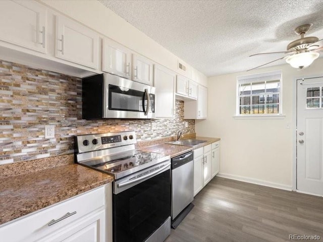 kitchen featuring backsplash, white cabinetry, sink, and appliances with stainless steel finishes