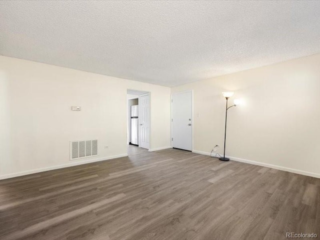 spare room with dark hardwood / wood-style flooring and a textured ceiling