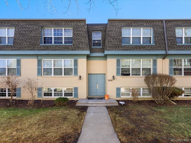 townhome / multi-family property featuring a front lawn