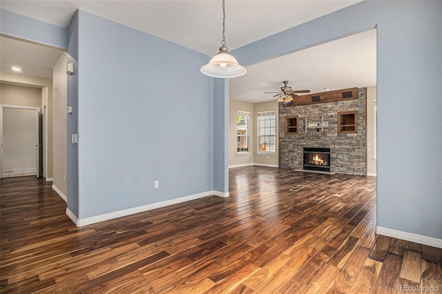 3389 Willowrun Dr, Castle Rock, CO 80109 - unfurnished living room featuring ceiling fan, dark wood-style flooring, baseboards, and a fireplace
