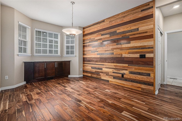 3389 Willowrun Dr, Castle Rock, CO 80109 - unfurnished dining area with wood walls, dark wood-style flooring, baseboards, and recessed lighting