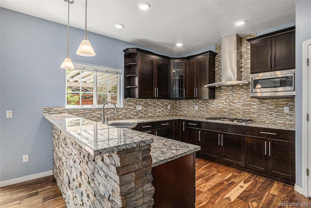 3389 Willowrun Dr, Castle Rock, CO 80109 - kitchen featuring appliances with stainless steel finishes, a sink, wall chimney exhaust hood, a peninsula, and light stone counters