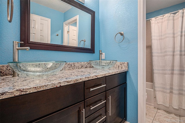 3389 Willowrun Dr, Castle Rock, CO 80109 - bathroom featuring vanity, a textured wall, shower / bath combination with curtain, and tile patterned floors