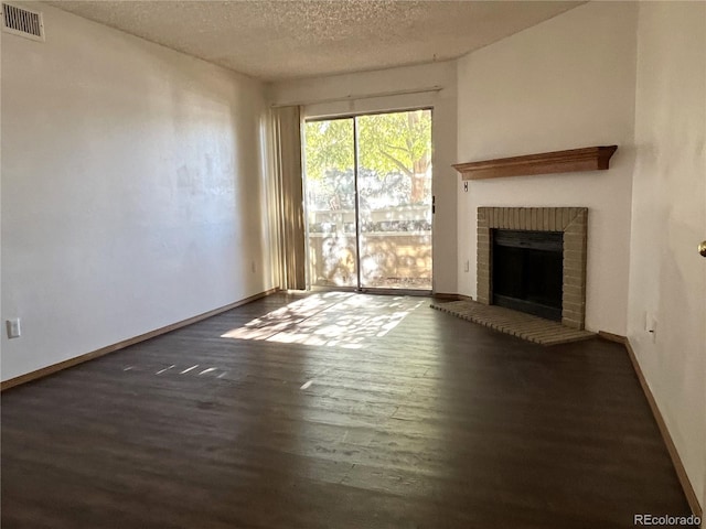 unfurnished living room with a textured ceiling, a fireplace, and dark hardwood / wood-style floors