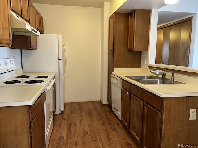 kitchen featuring white appliances, sink, and dark wood-type flooring